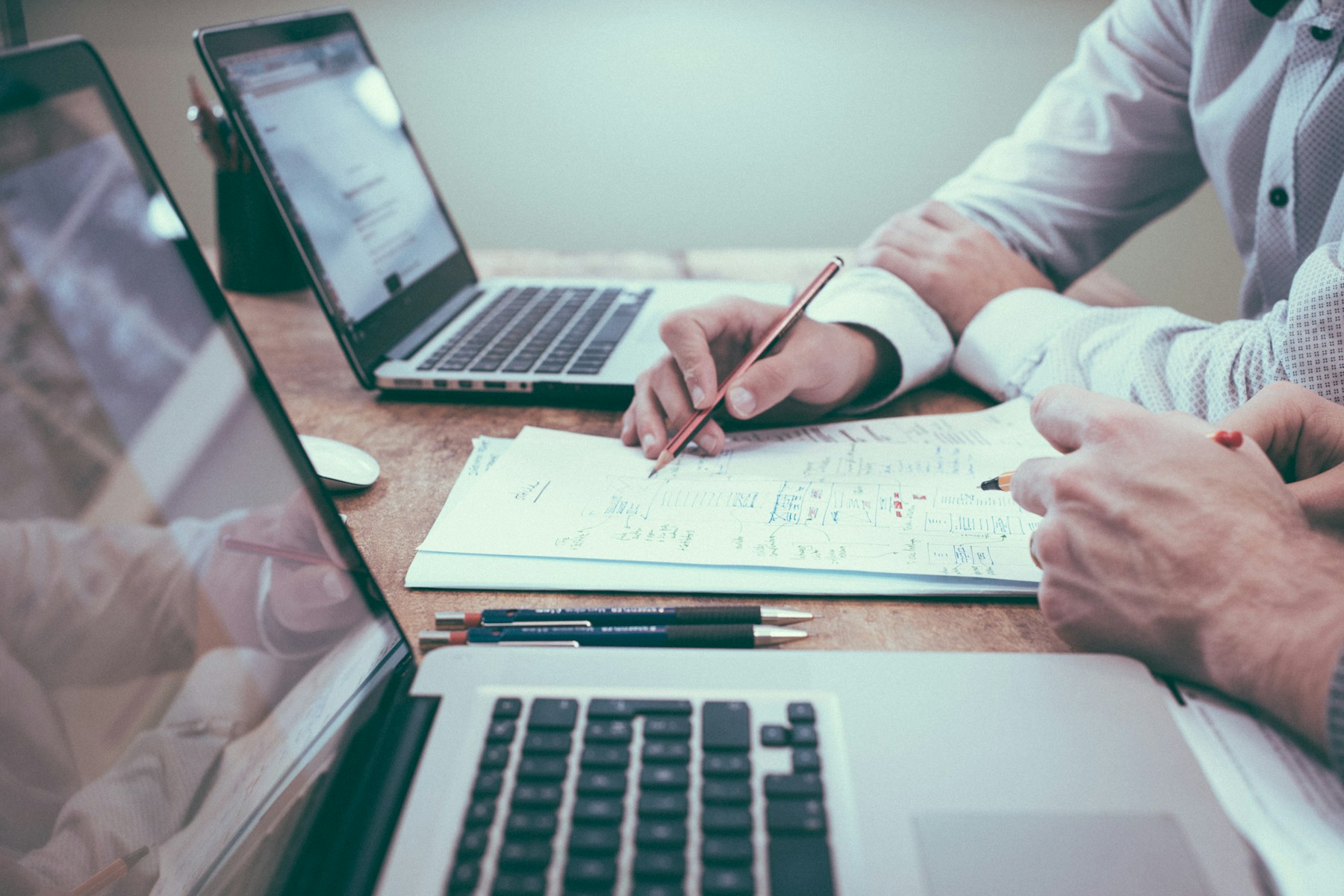 Business owners reviewing financial plans and reports together at a desk with laptops